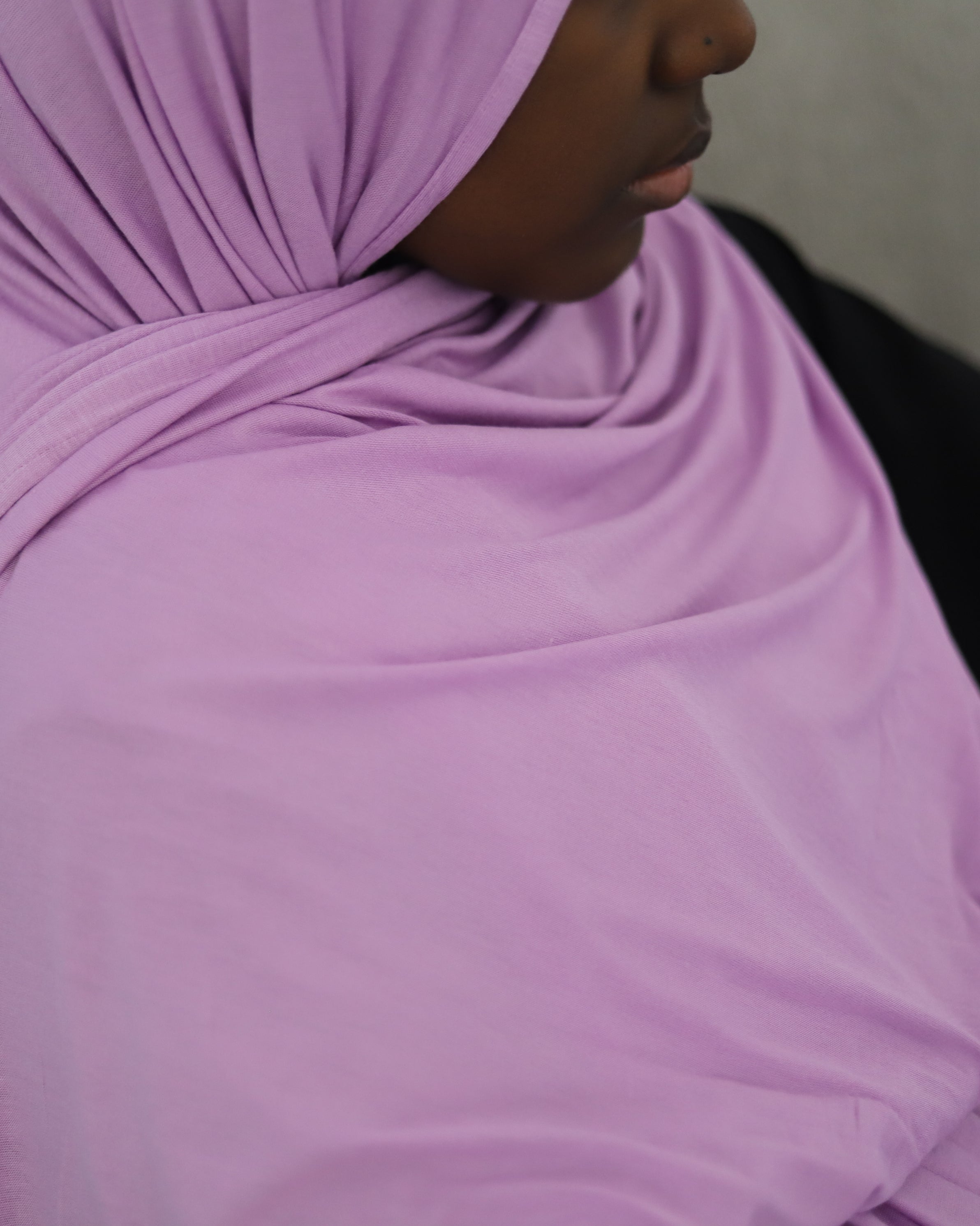 A lady wearing a lilac-colored jersey hijab.